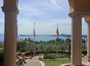 eyJkZSI6IlZpc3RhIGRhbCBWaXR0b3JpYWxlIHN1bCBMYWdvIGRpIEdhcmRhLCBBdXNzaWNodCBhdWYgZGVuIEdhcmRhc2VlIn0=