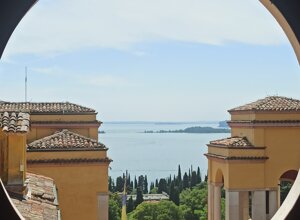 eyJkZSI6IlZpc3RhIGRhbCBWaXR0b3JpYWxlIHN1bCBMYWdvIGRpIEdhcmRhLCBBdXNzaWNodCBhdWYgZGVuIEdhcmRhc2VlIn0=