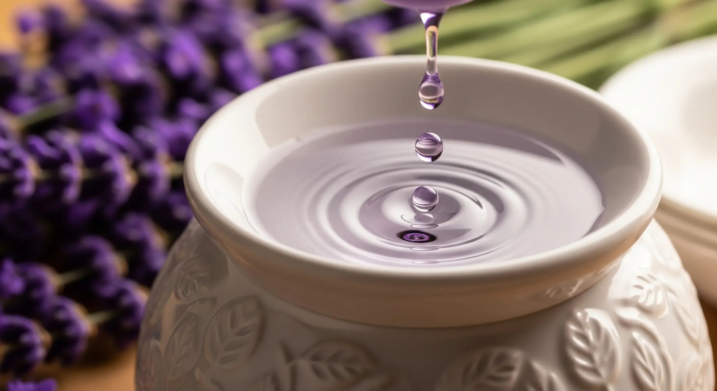 Goccia di olio essenziale di lavanda che cade in un diffusore per aromaterapia, rimedio naturale per l'insonnia.