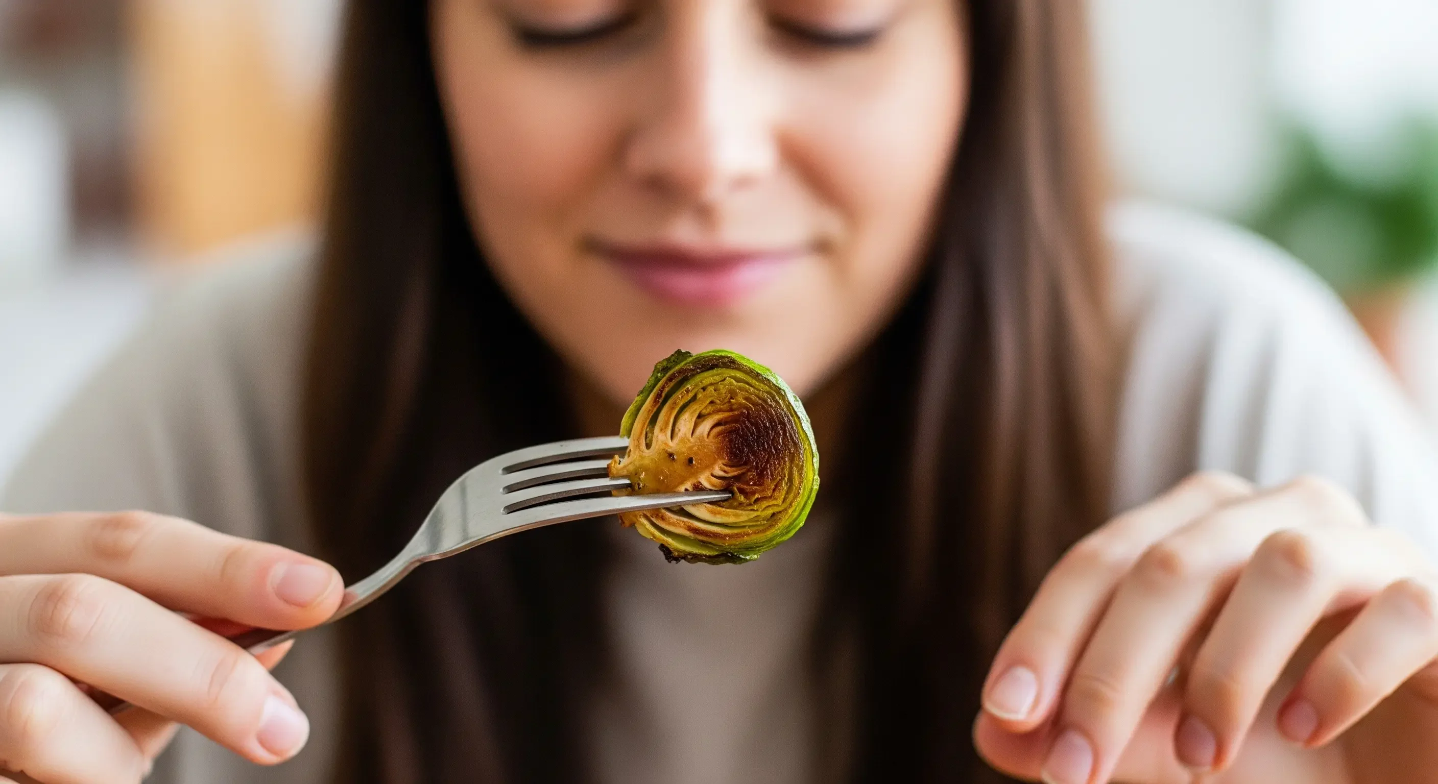 Donna che assapora consapevolmente un boccone di cibo, una pratica di mindful eating per migliorare la digestione e il gusto.