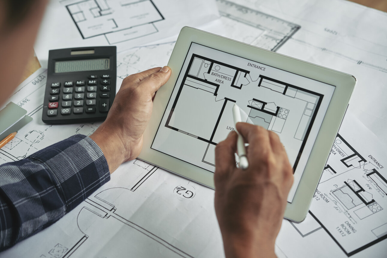 cropped-view-male-hands-holding-digital-pad-examining-blueprint.jpeg