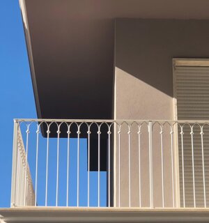 Ringhiera in ferro battuto con decorazioni geometriche su balcone privato