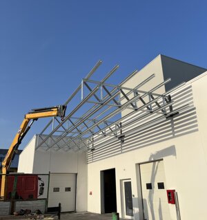 Copertura in acciaio zincato per edificio industriale in fase di montaggio con gru
