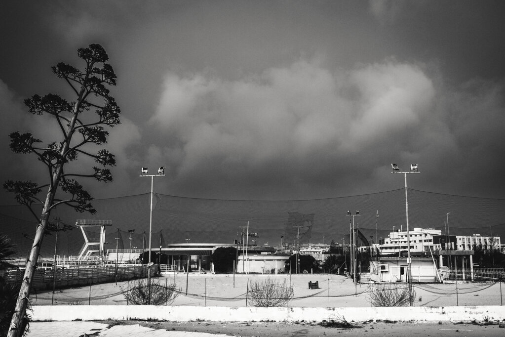 Campo da gioco vuoto di uno stabilimento balneare abbandonato, sotto un cielo di tempesta a Ostia. - Empty playing field at an abandoned beach club beneath a stormy sky in Ostia.