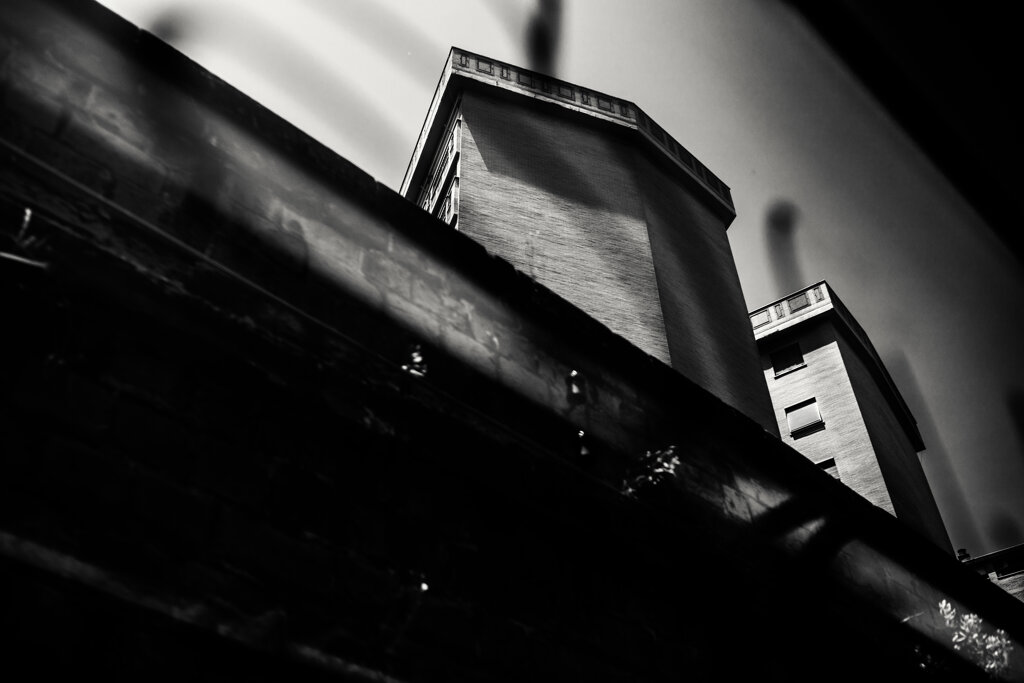 Fotografia in bianco e nero di Antonio Crialesi di un palazzo in zona Ostiense a Roma visto da un vagone del treno Roma-Lido (Metromare) - Black and white photograph by Antonio Crialesi of a building in the Ostiense area of Rome, seen from a Rome-Lido (Metromare) train car