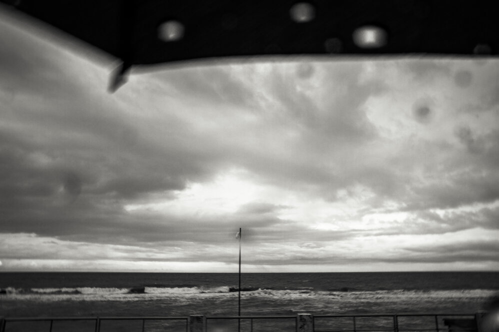 Fotografia in bianco e nero di Antonio Crialesi di un palazzo in zona Ostiense visto da un vagone del treno Roma-Lido (Metromare) - Black and white photograph by Antonio Crialesi of a building in the Ostiense area seen from a train car on the Rome-Lido line (Metromare)