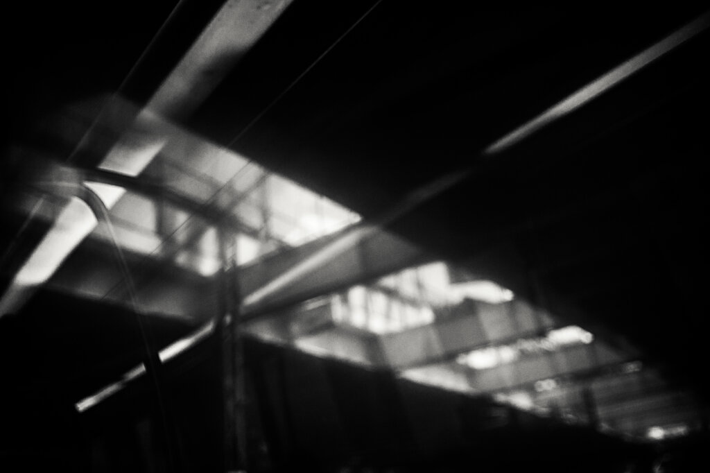 Fotografia in bianco e nero di Antonio Crialesi: il ponte Spizzichino alla Garbatella visto da un finestrino di un vagone della linea metropolitana Metromare (Roma, Italia). - Black-and-white photograph by Antonio Crialesi: the Ponte Spizzichino in the Garbatella area, seen through the window of a Metromare metropolitan railway carriage (Rome, Italy).