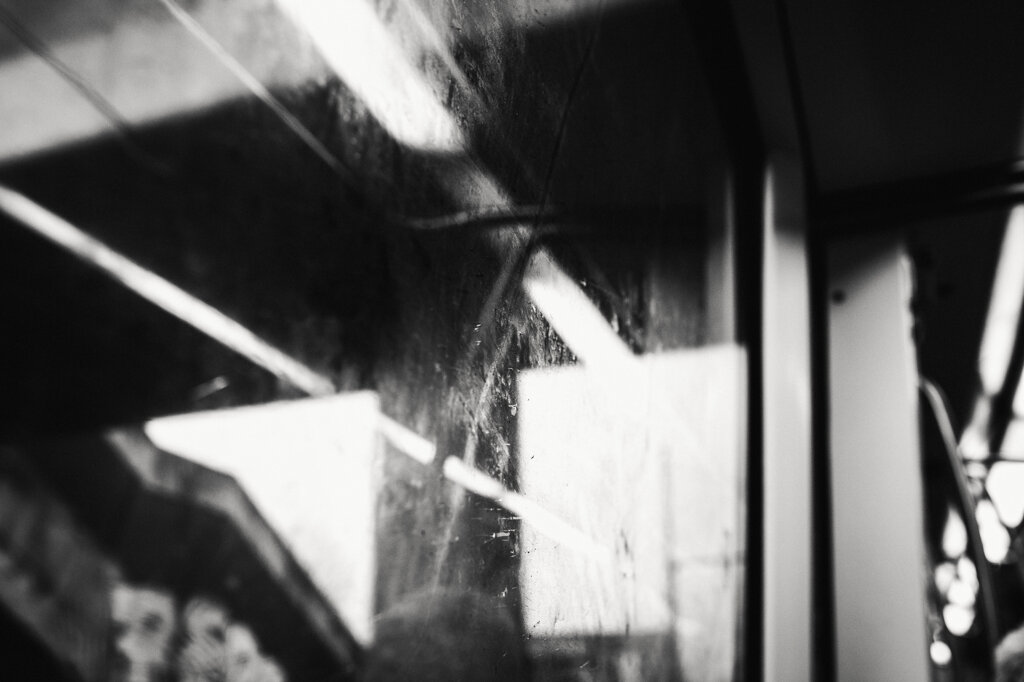 Fotografia in bianco e nero di Antonio Crialesi: paesaggio urbano visto da un finestrino di un vagone della linea metropolitana Metromare (Roma, Italia). - Black-and-white photograph by Antonio Crialesi: an urban landscape seen through the window of a Metromare metropolitan railway carriage (Rome, Italy).