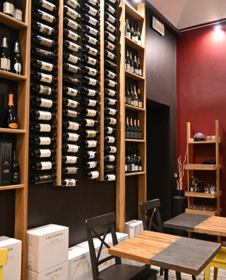 Saletta con espositore bottiglie e mobili di servizio in un wine-bar ad Alessandria