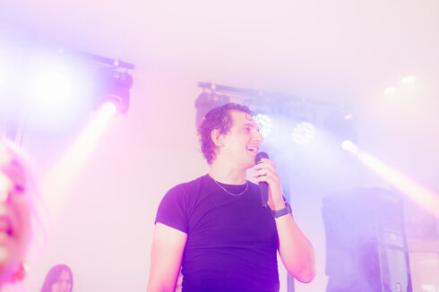 Cantante professionista durante un live show targato Vida Loca Events con scenografia luminosa.