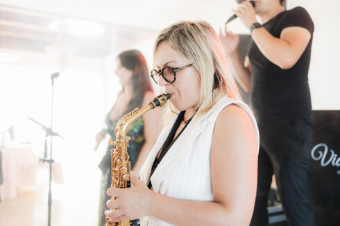 Musicista suona il sassofono durante un evento live di Vida Loca Events con band dal vivo.
