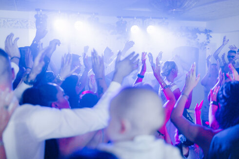 Pubblico che balla durante un evento Vida Loca con effetti speciali e luci da discoteca.