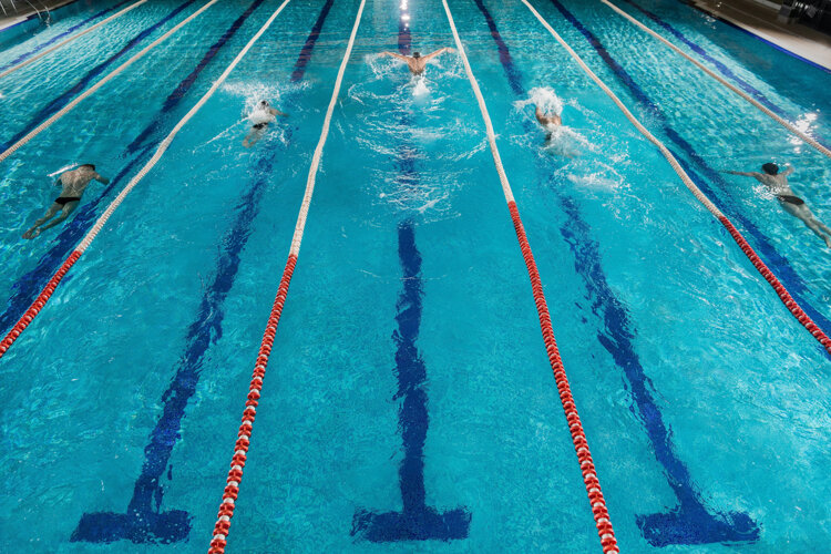 five-swimmers-racing-against-each-other-in-a-swiming-pool.jpeg
