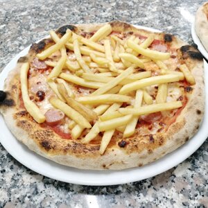Pizza appena sfornata con wurstel e patatile