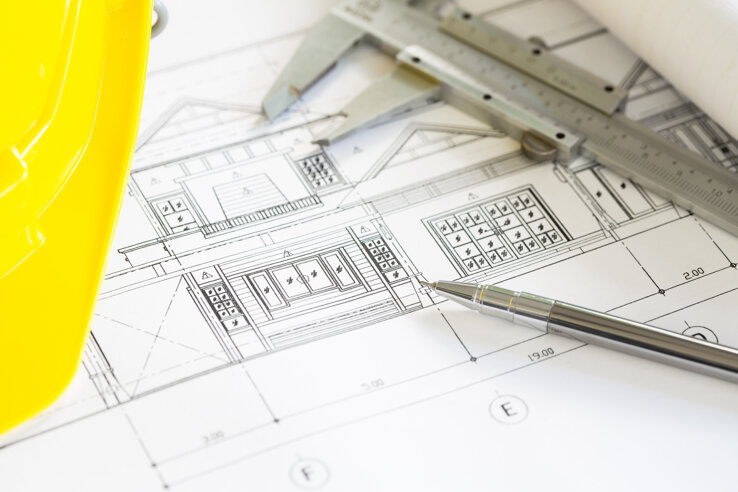 construction-plans-with-yellow-helmet-drawing-tools-bluep.jpeg