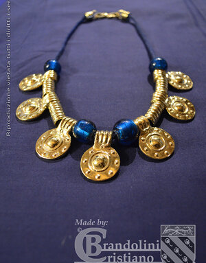 Collana longobarda femminile a pendagli in lega di similoro e vaghi in vetro blu. VI-VII secolo d.C.