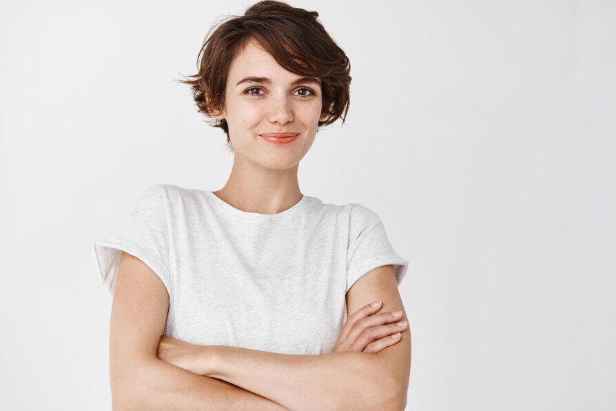 ritratto-di-donna-sicura-e-felice-con-i-capelli-corti-braccia-incrociate-sul-petto-come-professionista-e-sorridente-in-piedi-contro-il-muro-bianco-white.jpeg