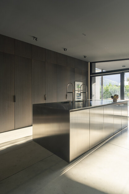 Cucina di Casa AF con bancone in acciaio inox e armadiatura in legno a tutta altezza