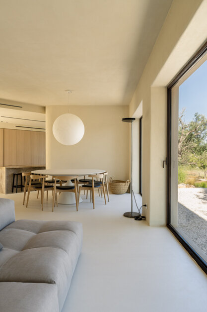 Soggiorno minimalista di Casa E con ampie vetrate affacciate sulla campagna pugliese