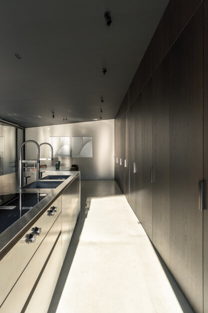 Cucina di Casa AF con bancone in acciaio inox e armadiatura in legno a tutta altezza