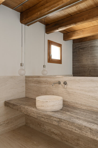 Effevu House, bagno con lavabo in travertino e finestra in rovere