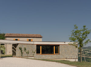 Effevu House, fronte d'ingresso con il nuovo volume vetrato e il casale storico