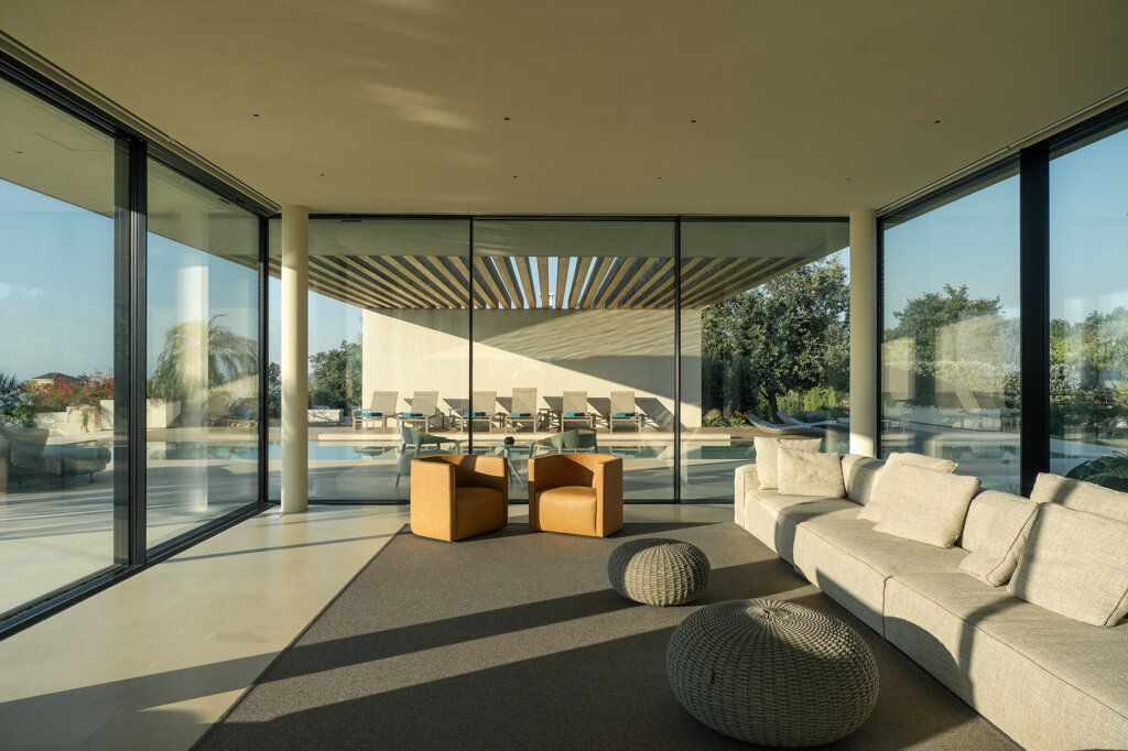 Living open space di Villa Hermosa con vetrate a scomparsa aperte sul paesaggio siciliano