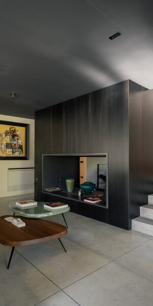 Zona giorno di Casa AF con camino centrale e vetrate a tutta altezza sul giardino