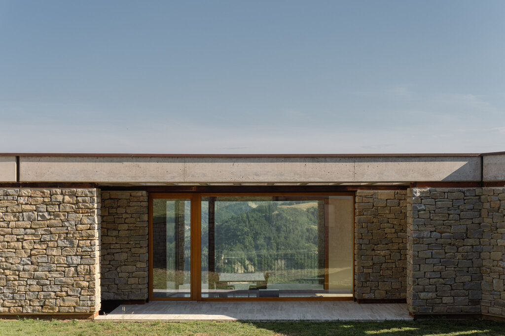 Casa in sasso originaria e volume contemporaneo in dialogo sul declivio collinare, Ellevuelle Architetti