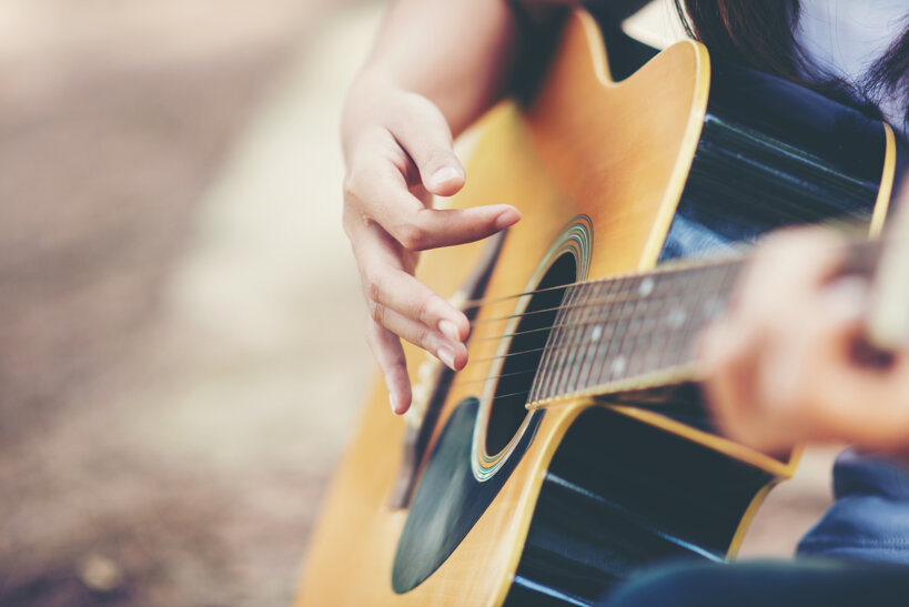 ritratto-di-una-bella-ragazza-suonare-la-chitarra-con-la-bici-in-natura.jpeg