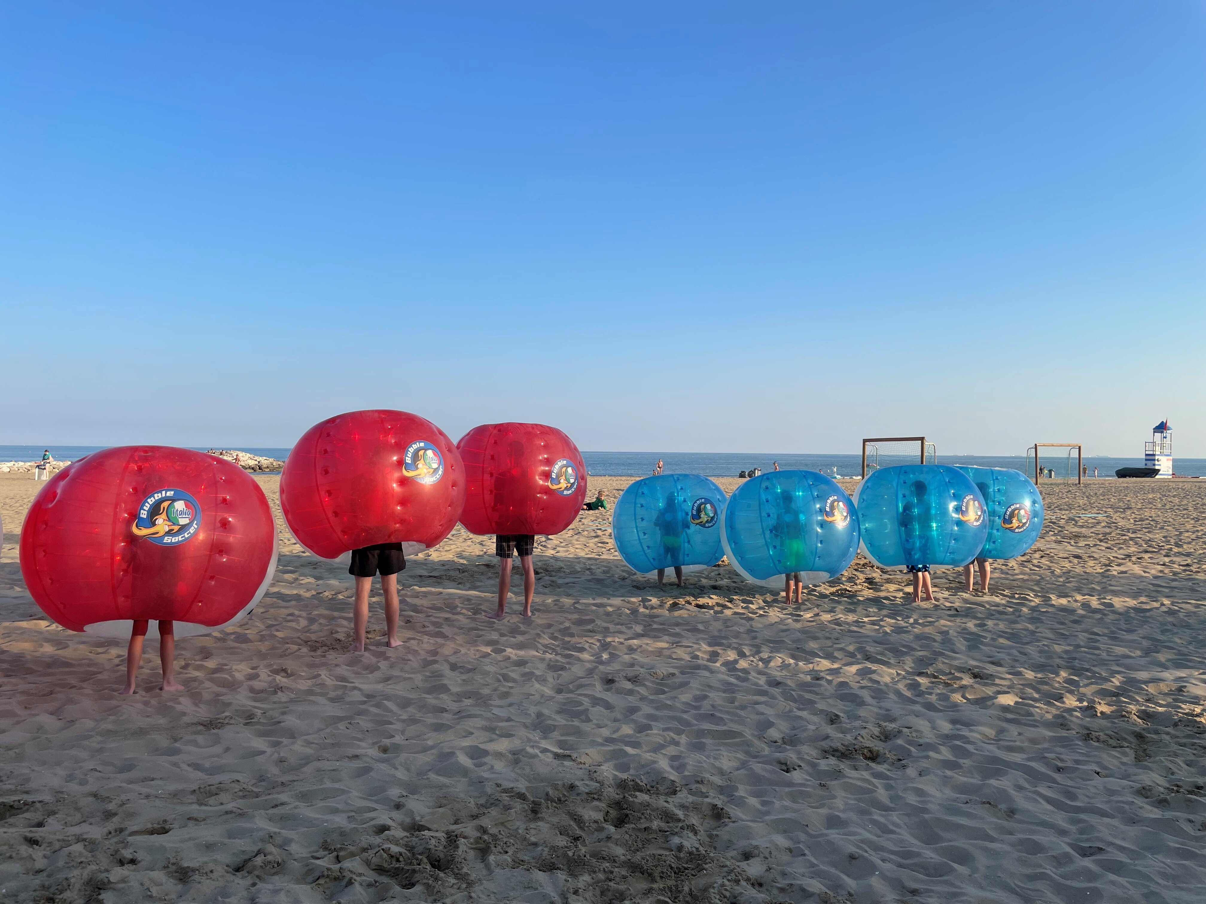 gente che gioca a bubble soccer in campeggio in spiaggia