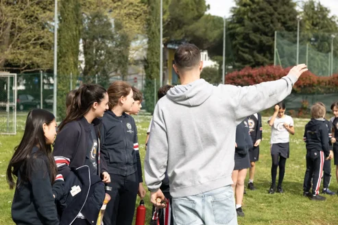 istruttore di bubble soccer italia che spiega le regole di gioco agli alunni della scuola durante una lezione di un progetto sportivo