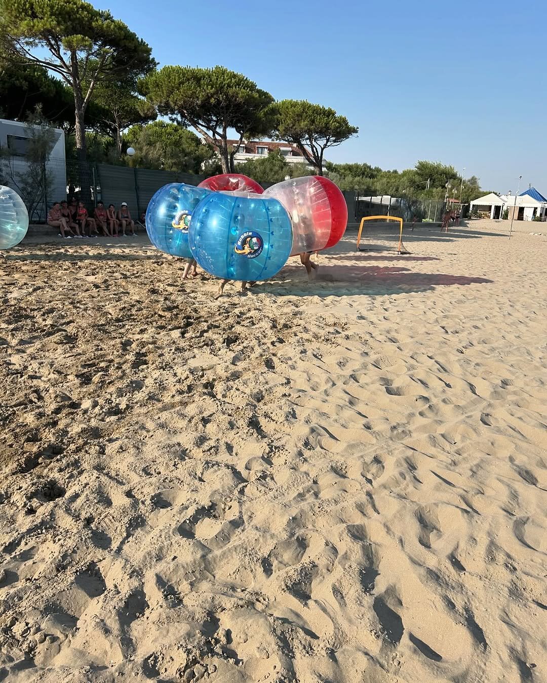bambini che giocano a bubble soccer in spiaggia