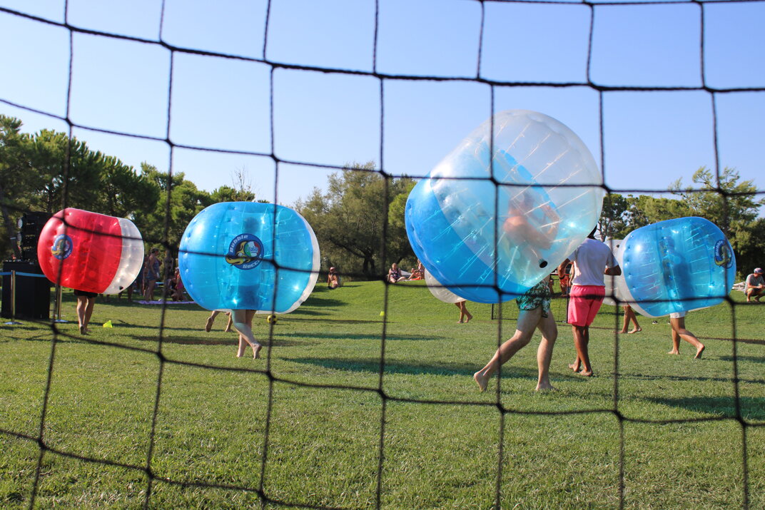 gente che gioca su un prato a bubble soccer in un campeggio a JESOLO