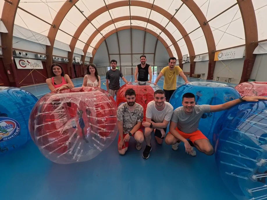 ragazzi che giocano a bubble soccer con l'attrezzatura di Bubble Soccer italia in un campo al coperto sintetico