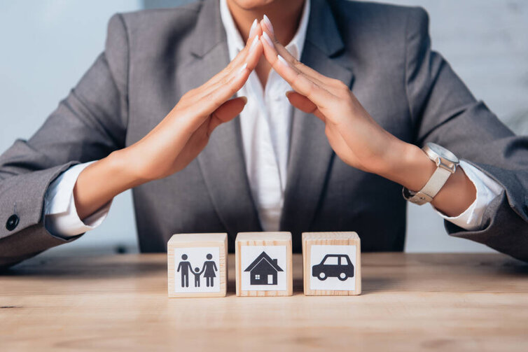 stock-photo-cropped-view-lawyer-holding-hands-wooden-cubes-family-car-house.jpeg