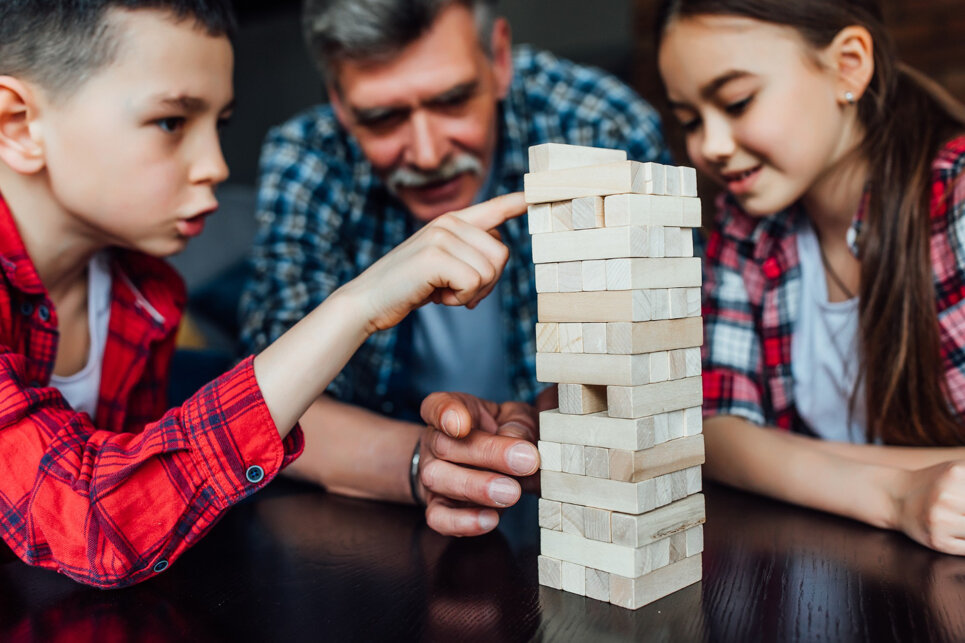 concentrati-su-due-fratelli-felici-che-giocano-con-il-nonno-che-gioca-gioiosamente-con-i-blocchi-di-legno-a-casa.jpeg