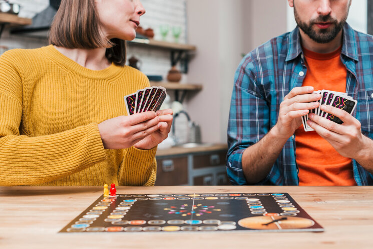 giovani-coppie-che-giocano-gioco-da-tavolo-sullo-scrittorio-di-legno.jpeg