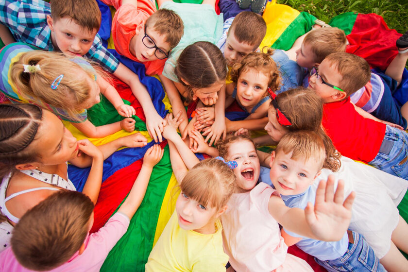 bambini-con-vista-dall-alto-che-si-divertono-sdraiati-su-un-tappetino-colorato-collegando-le-mani-diversi-bambini-che-si-tengono-per-mano-sorridenti-guardando-la-telecamera-bambini-al-campo-diurno-che-cercano-di-riposare-dopo-i-giochi-attiv.jpeg