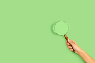 woman-hand-holding-magnifying-glass-green-background-with-copy-space.jpeg