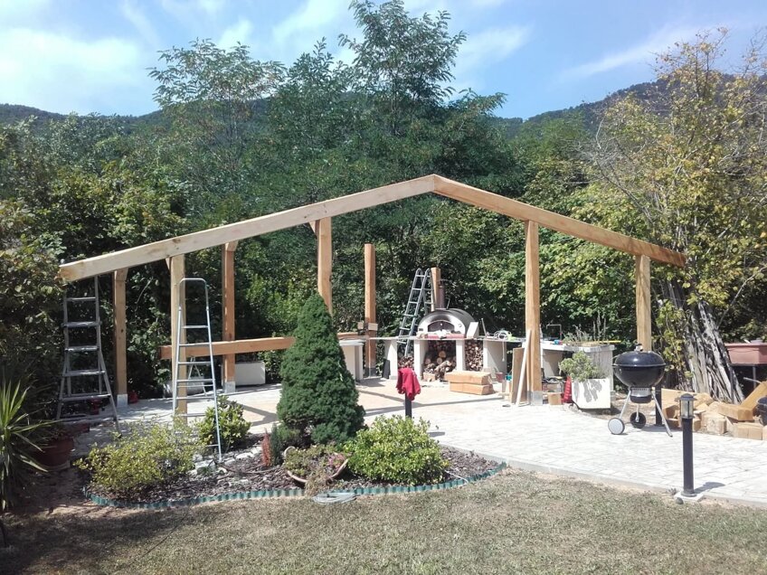 Struttura in legno per tettoia in fase di montaggio, con travi e colonne, lavorazione artigianale di Bespowoodart genova Struttura in legno per tettoia in fase di montaggio, con travi e colonne, lavorazione artigianale di Bespowoodart genova