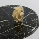 tavolino-rotondo-con-top-in-marmo-nero-e-base-con-logo-in-oro-cromato