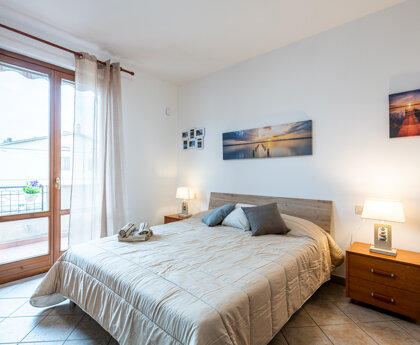 Letto e porta finestra che affaccia sul balcone