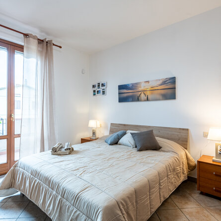 Letto e porta finestra che affaccia sul balcone