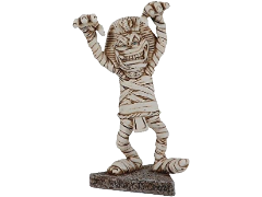Statuina Les Alpes di una mummia in stile umoristico, avvolta in bende con copricapo faraonico e un'espressione divertita, con le braccia sollevate e una base in pietra con la scritta 