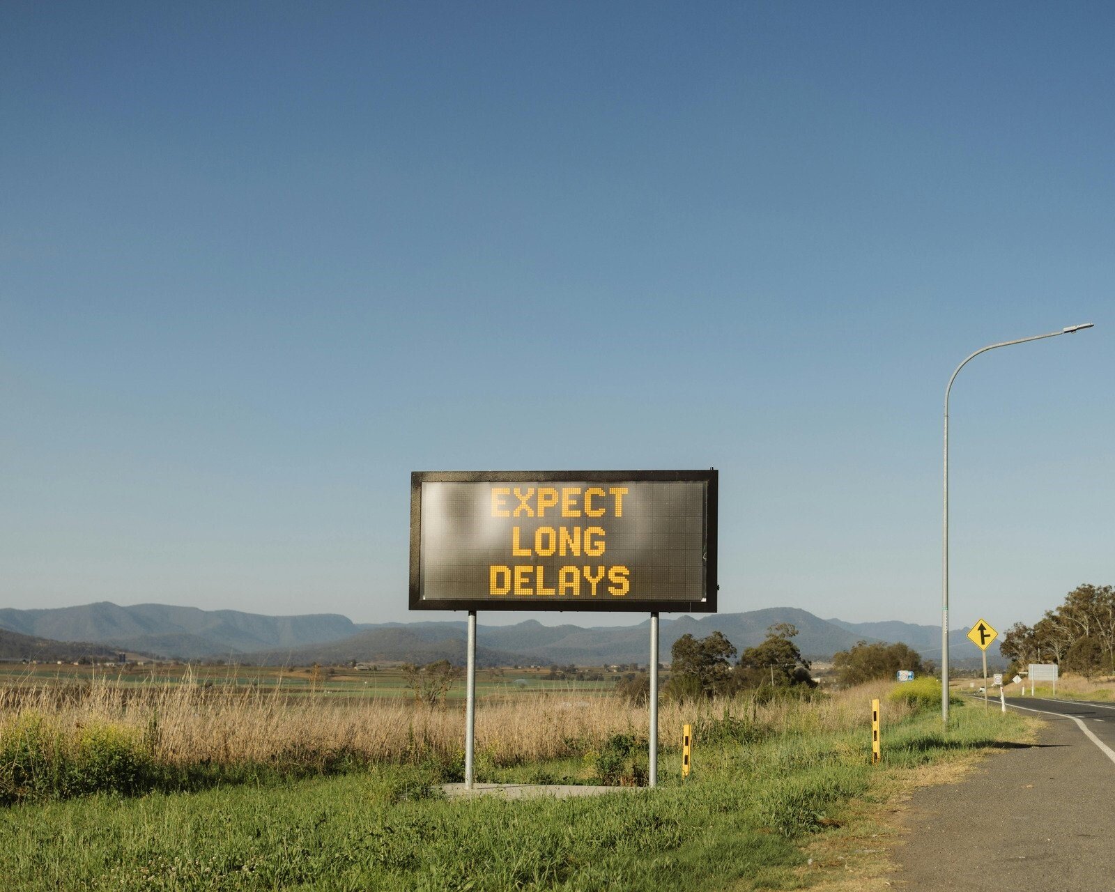 Vivere senza aspettative eccessive: psicologia e pace interiore la scritta Expect long delays