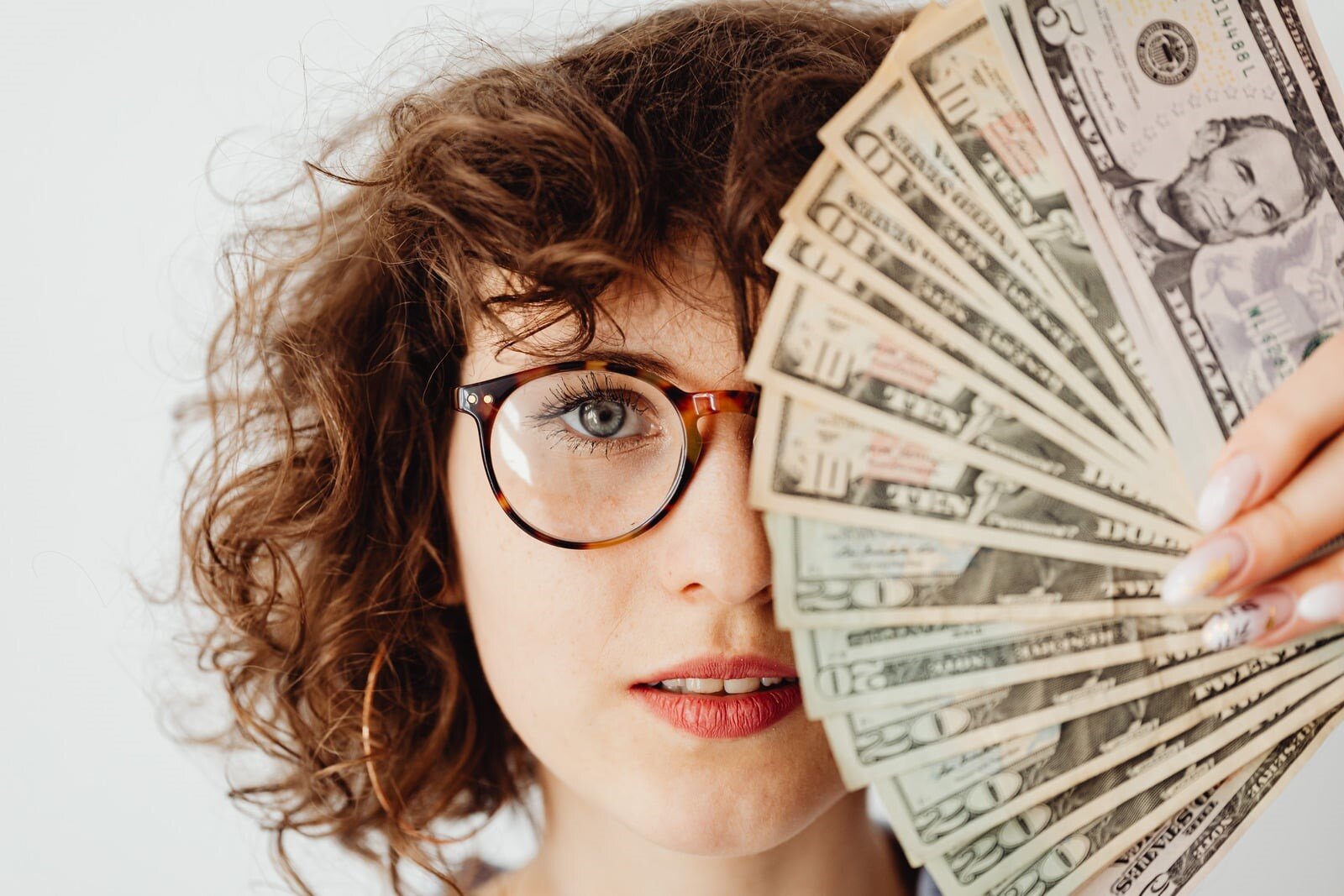 Senso di colpa per i soldi: come uscire dal loop dell'autogiudizio finanziario una donna con una mazzetta di soldi