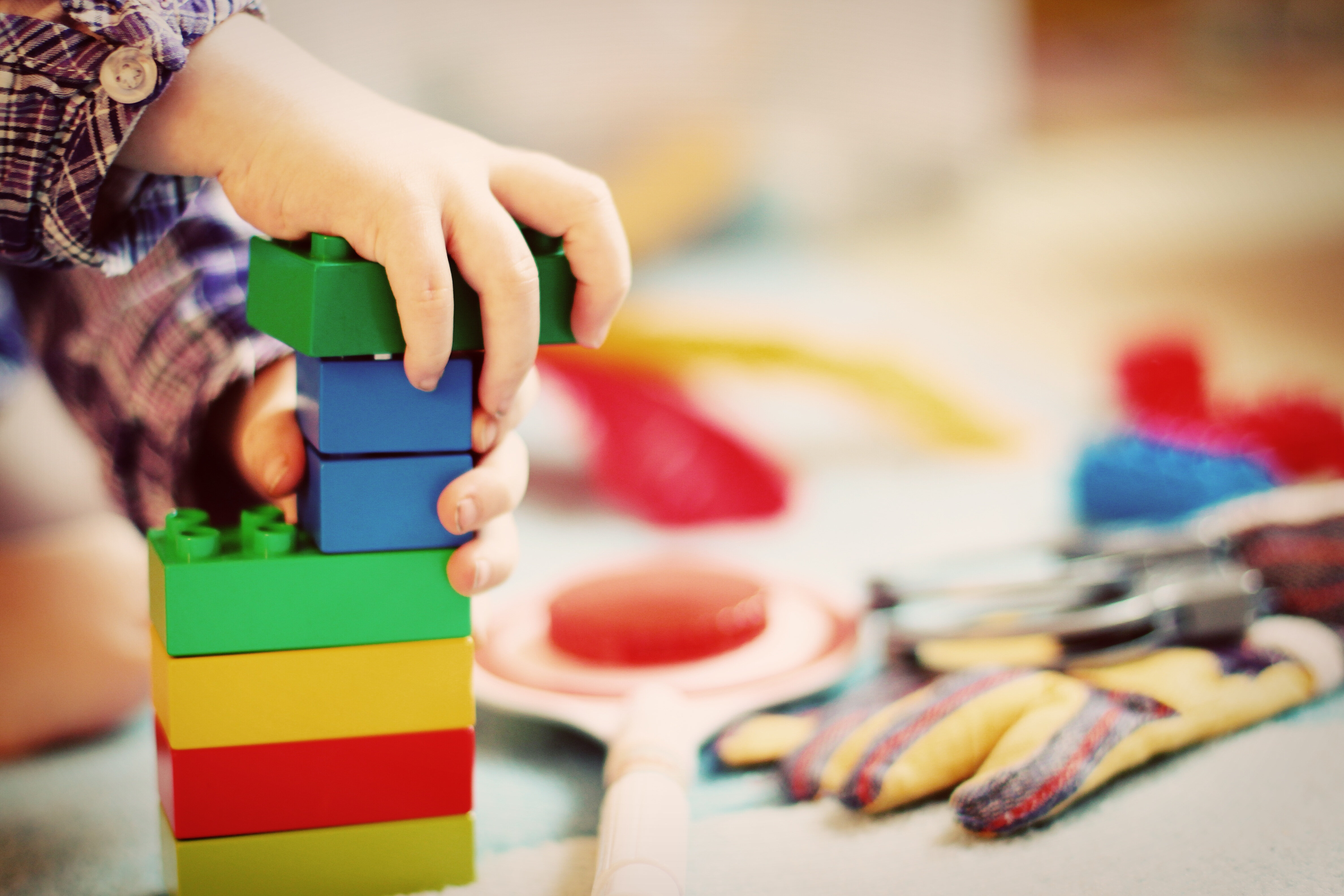 mani di bambino che giocano con le costruzioni