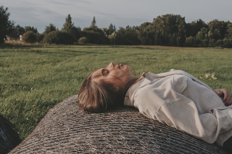 Ritmi sostenibili: come vivere senza esaurirsi nel quotidiano una donna si rilassa sdraiata in un prato