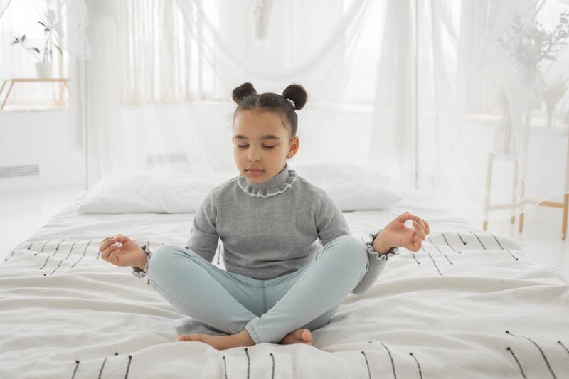 Mini-abitudini quotidiane di meditazione e visualizzazione per ripristinare energia mentale e connessione. una bambina in meditazione